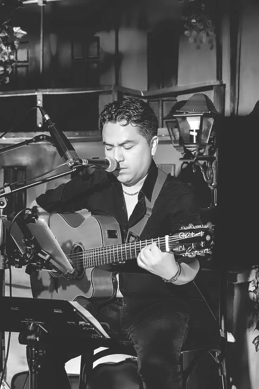 Retrato en blanco y negro tocando guitarra y cantando